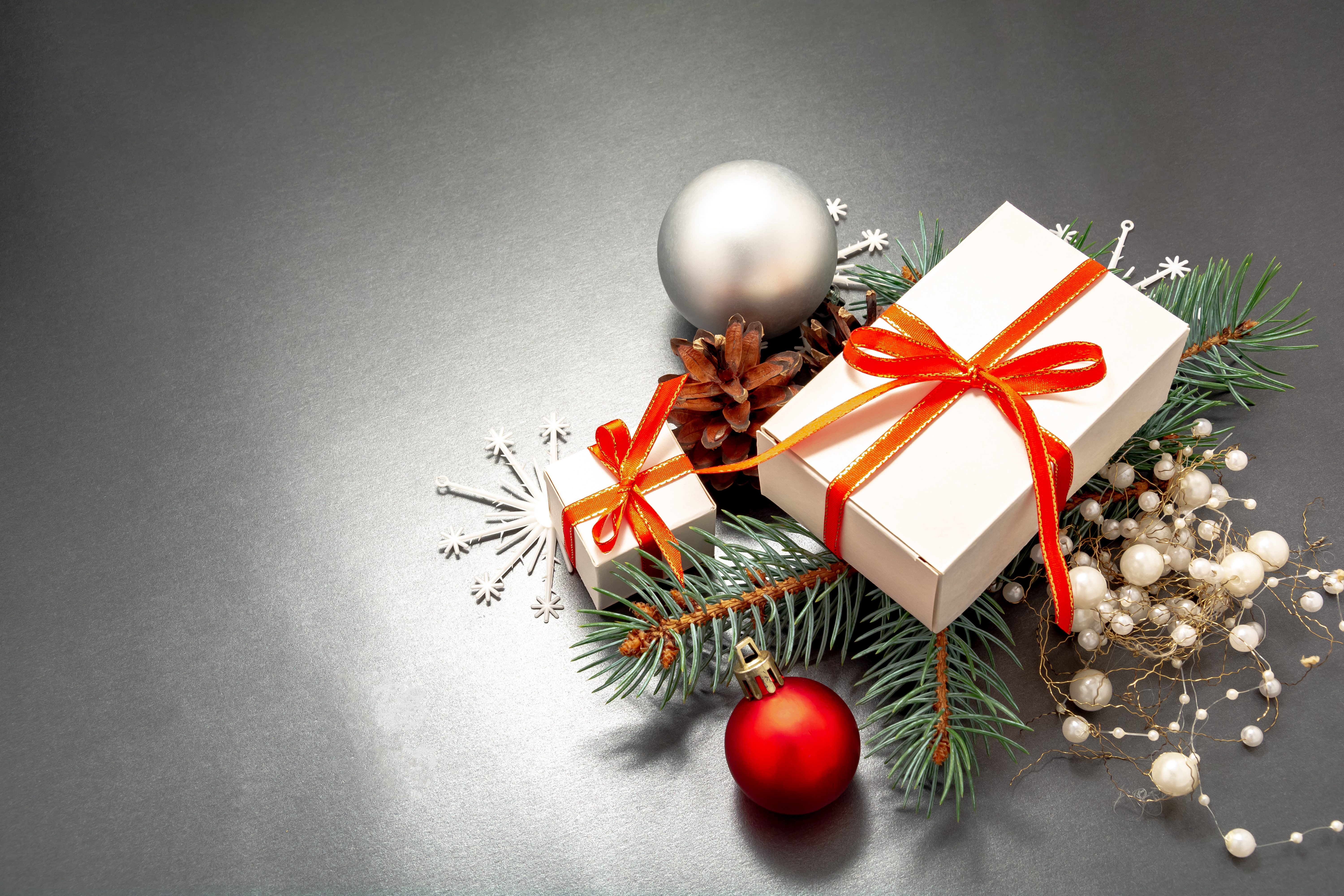 2021 Happy New Year, Merry Christmas decorations flatlay. Gift boxes, red ribbon, balls, spruce branch, snowflakes top view. Boxing Day banner template, black paper, copy space. Xmas concept mock up.
